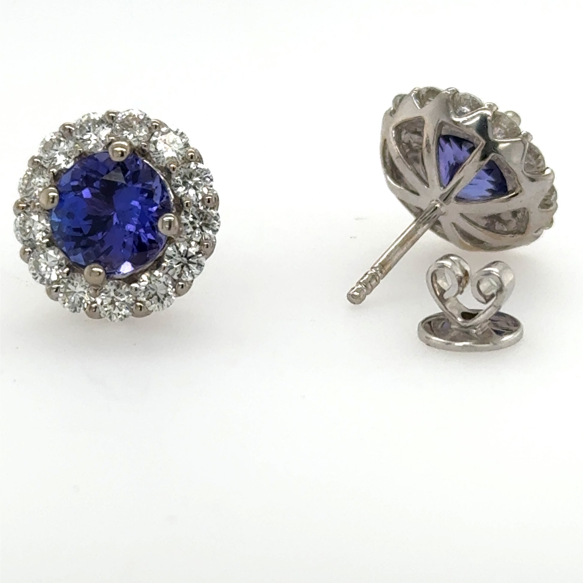 18K white gold stud earrings with round tanzanites and diamond halos.