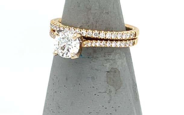 18K yellow gold wedding set with round solitaire and pavé diamond bands.