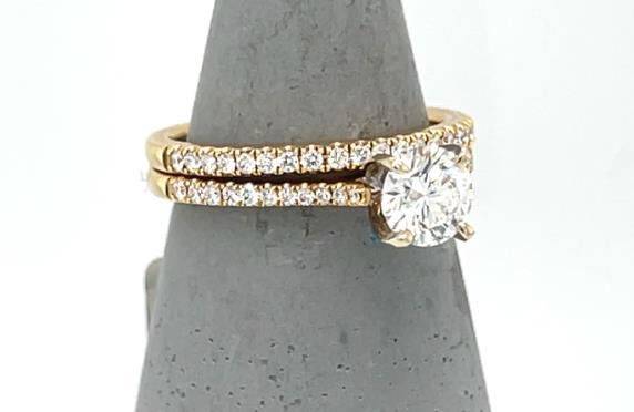 18K yellow gold wedding set with round solitaire and pavé diamond bands.