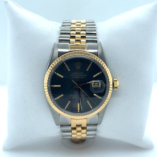 Two-tone steel and yellow gold Datejust with black dial, fluted bezel, jubilee bracelet, and date magnifier.