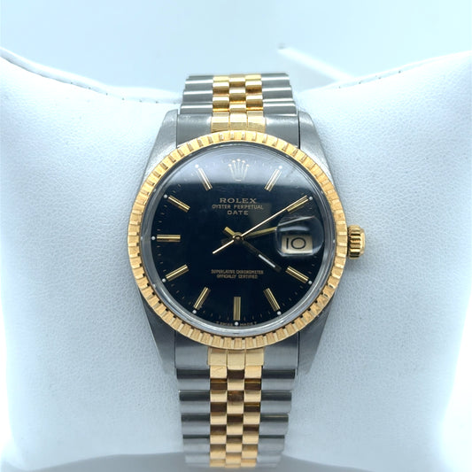 Two-tone Rolex Date watch with black dial, gold fluted bezel, Jubilee bracelet.