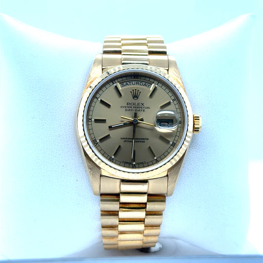 18K yellow gold Rolex Day-Date, champagne dial, fluted bezel, President bracelet.