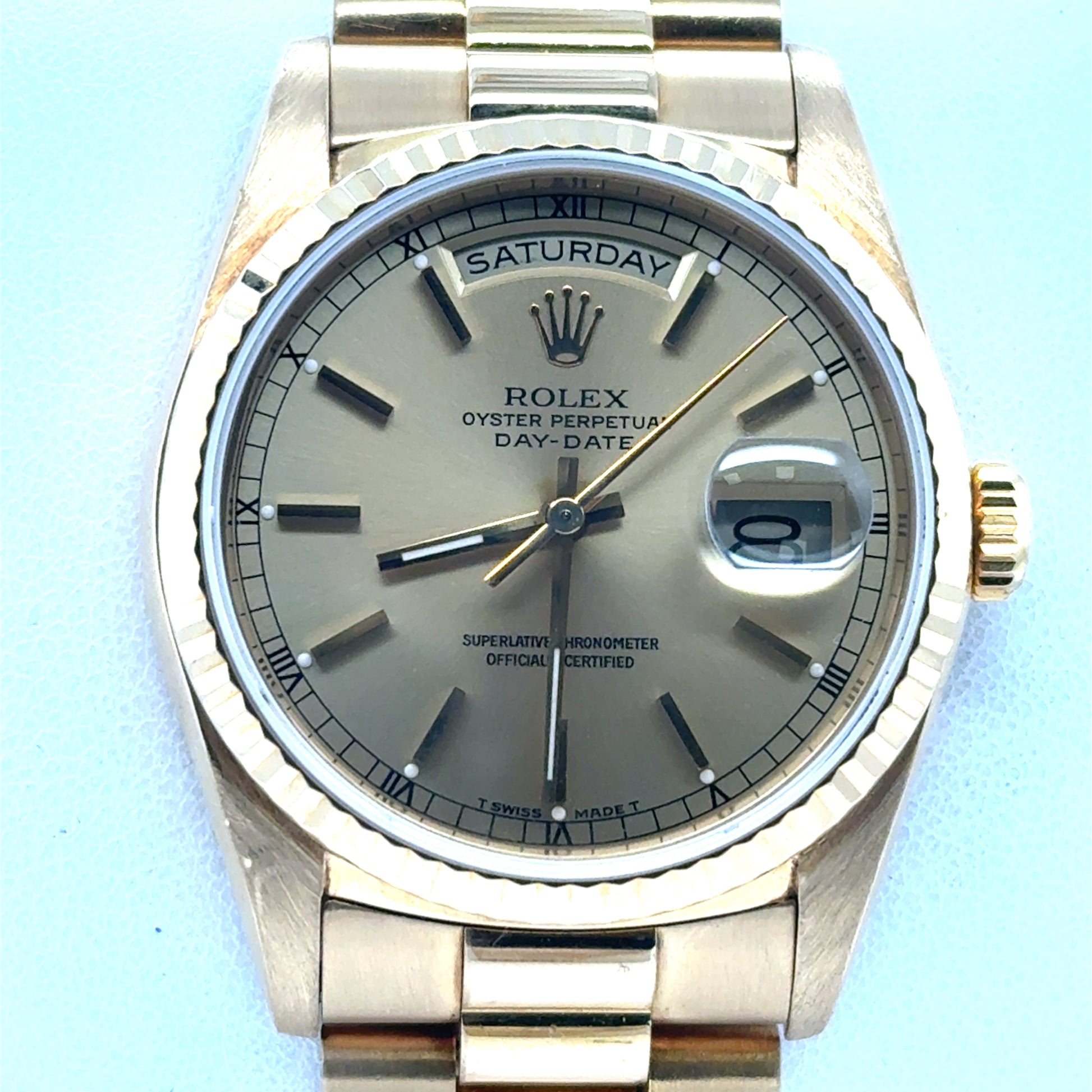 18K yellow gold Day-Date watch with champagne dial, fluted bezel, President bracelet.