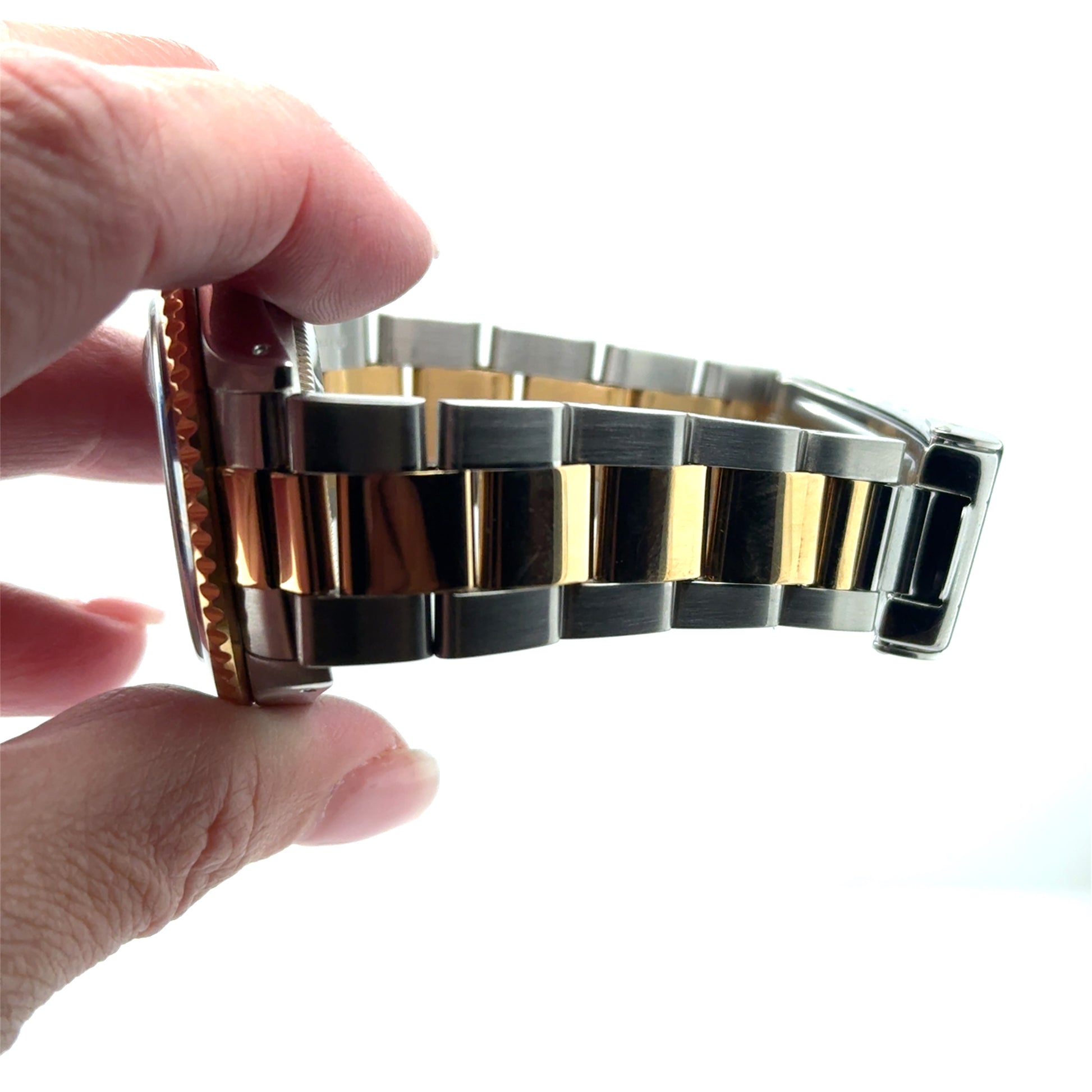 Close-up of a two-tone stainless steel and yellow gold Oyster bracelet with clasp.