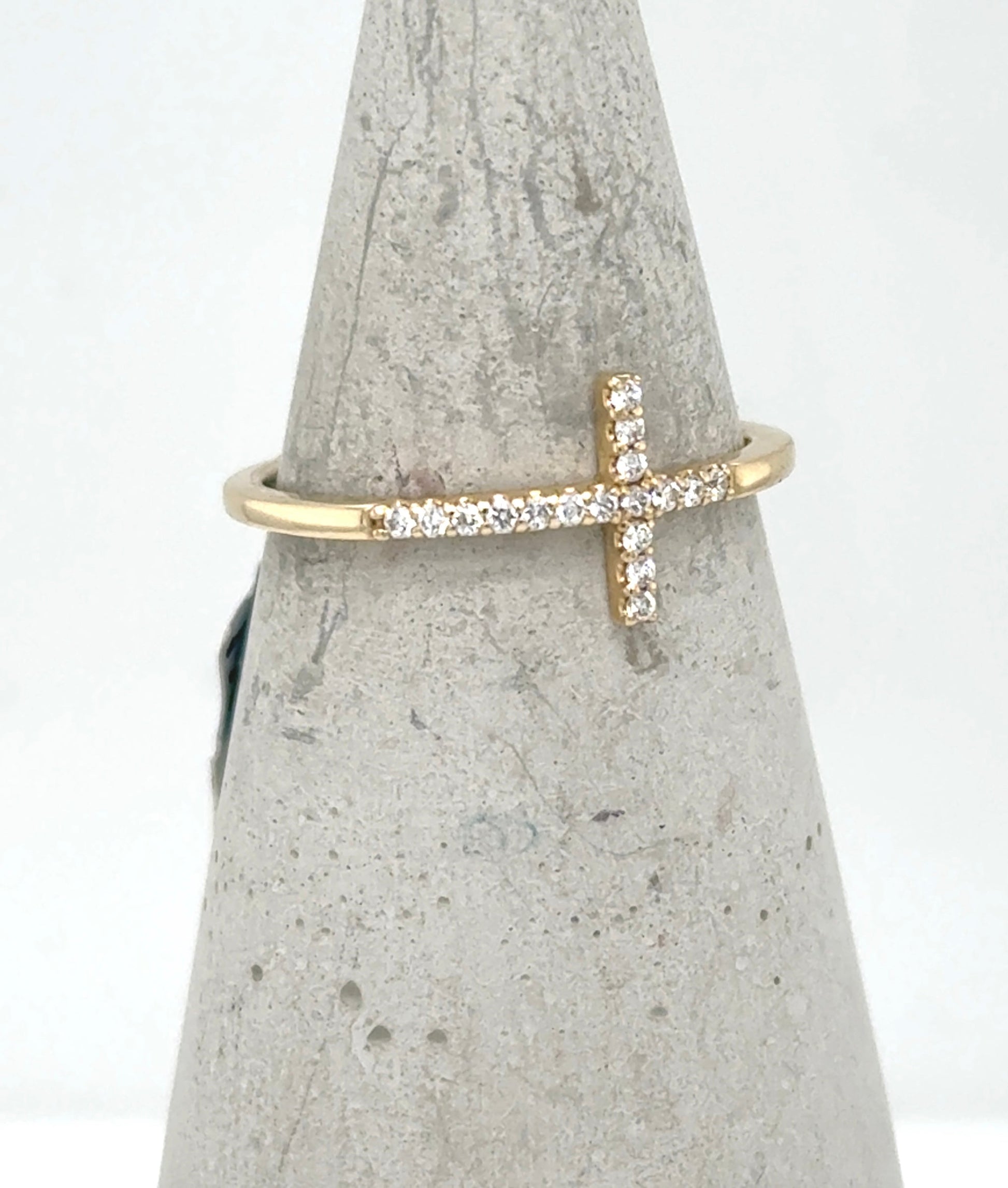 Yellow gold ring with a sideways diamond cross on a thin band.