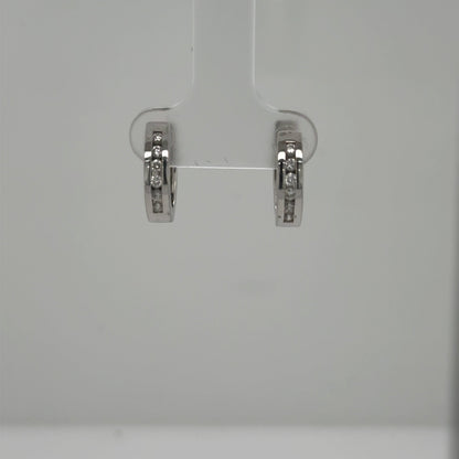 Small 14K white gold huggie hoops with channel‑set round diamonds.