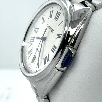 Stainless steel Cartier watch with silver Roman numeral dial, date window, blue crown.