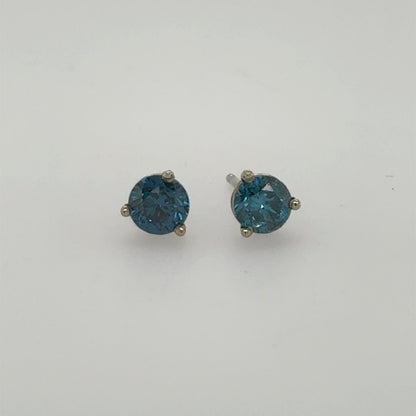 Round blue diamond stud earrings in 14K white gold three-prong settings.