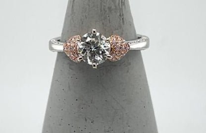 18K white gold ring with round center diamond and rose gold heart accents.