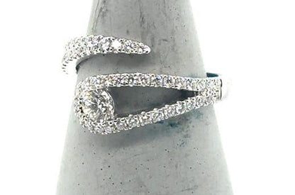 18K white gold bypass ring with pave diamonds and a channel-set round center.