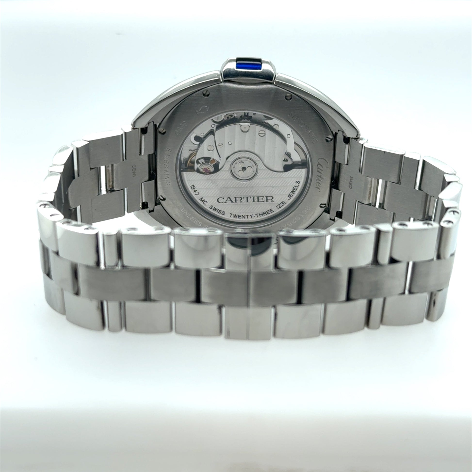 Stainless steel Cartier wristwatch showing exhibition caseback, automatic movement, and link bracelet.