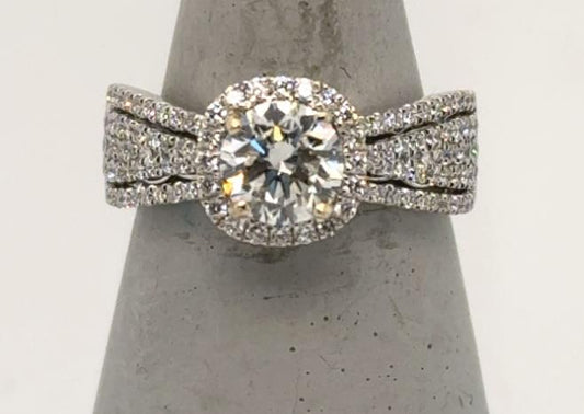 18K white gold ring with round diamond, cushion halo, split pavé band.