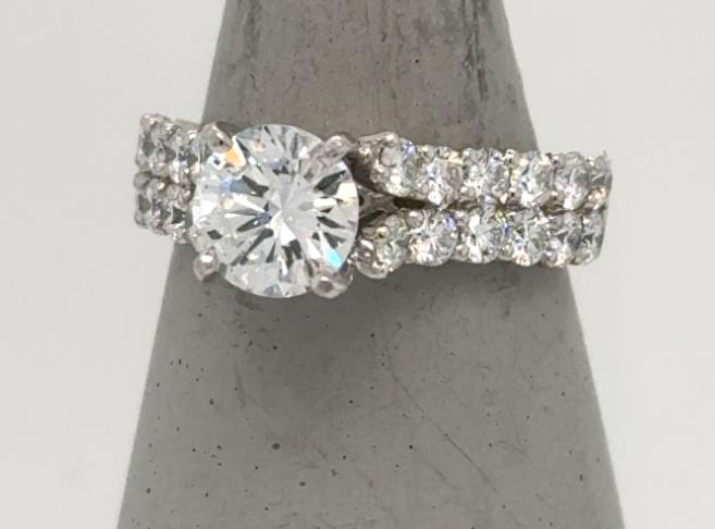 18K white gold ring with round solitaire and double row diamond band.