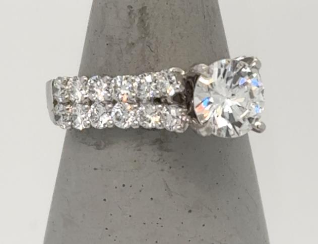 18K white gold ring with round solitaire diamond and double pavé diamond band.