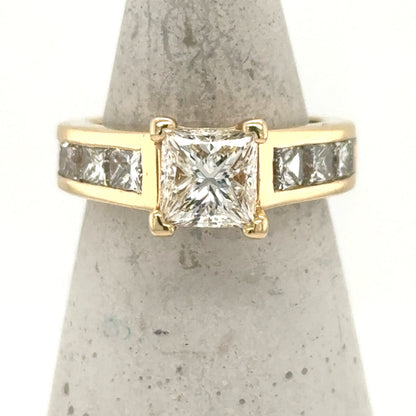 14K yellow gold ring with princess-cut center diamond and channel-set side diamonds.