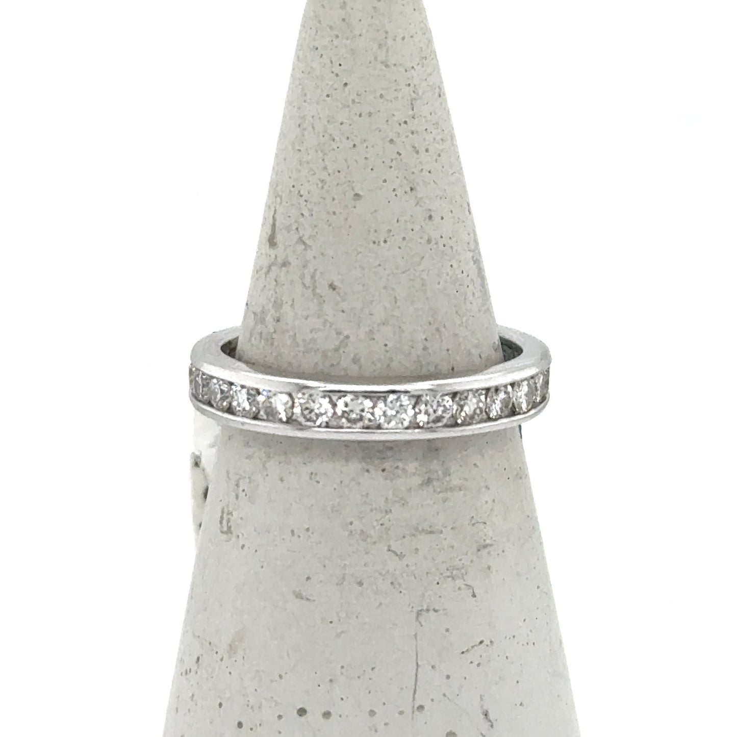 White gold eternity band with channel-set round diamonds around the ring.