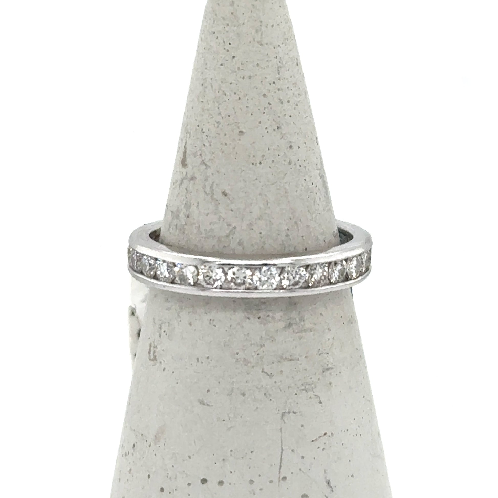 White gold eternity band with channel-set round diamonds around the ring.