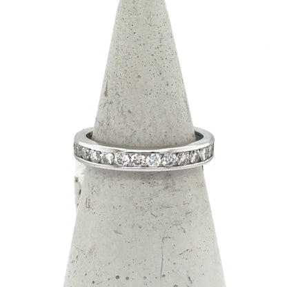 White gold eternity band with channel-set round diamonds around the ring.