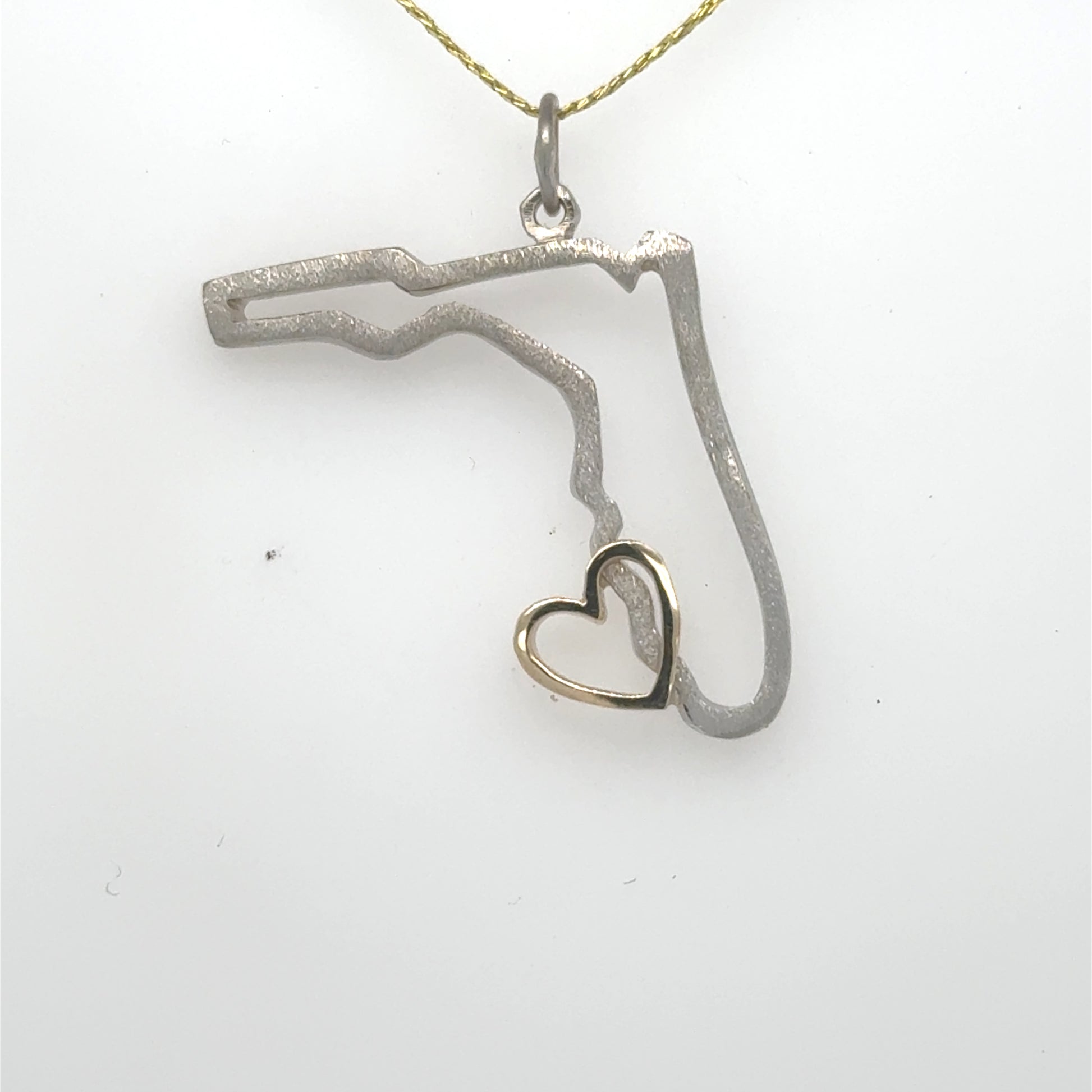 14K pendant outlining Florida in white gold with a small yellow gold heart.