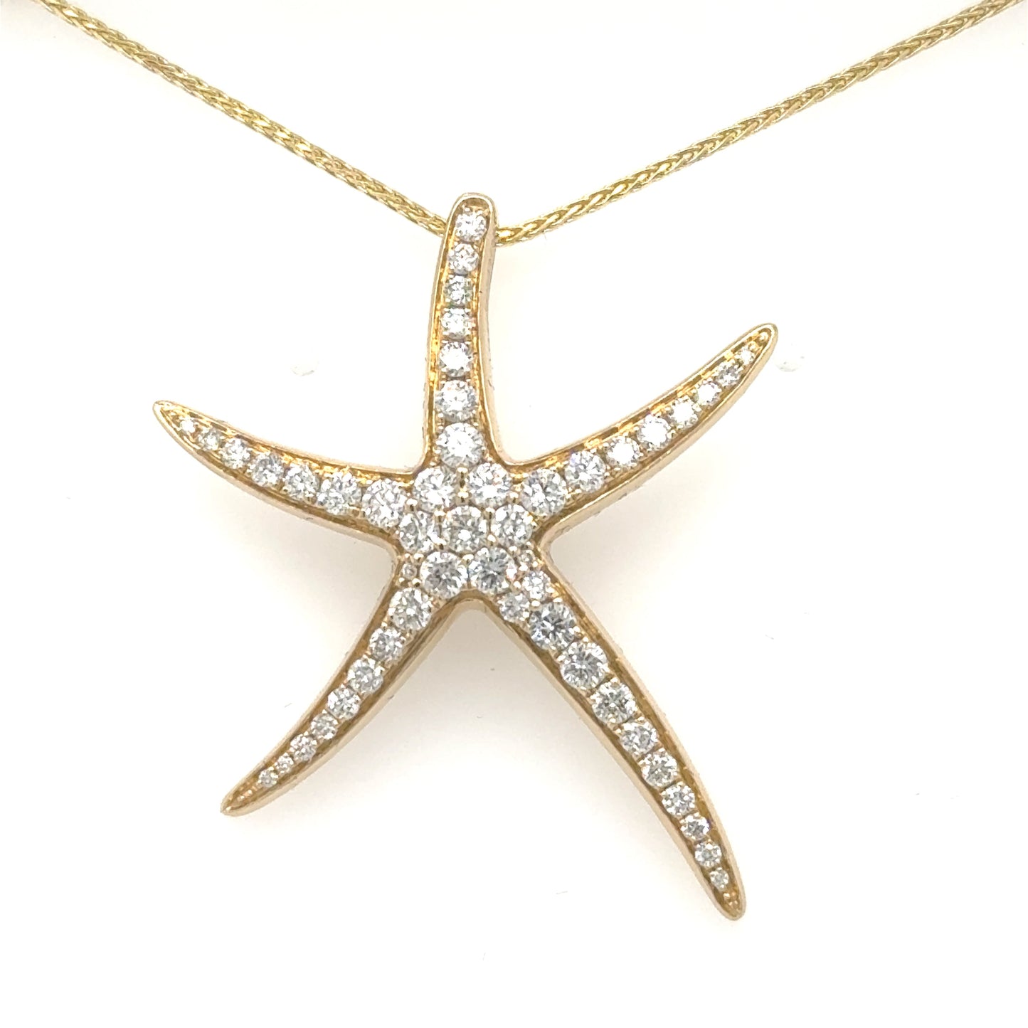 Yellow gold starfish pendant pave-set with round diamonds, shown on a fine chain.
