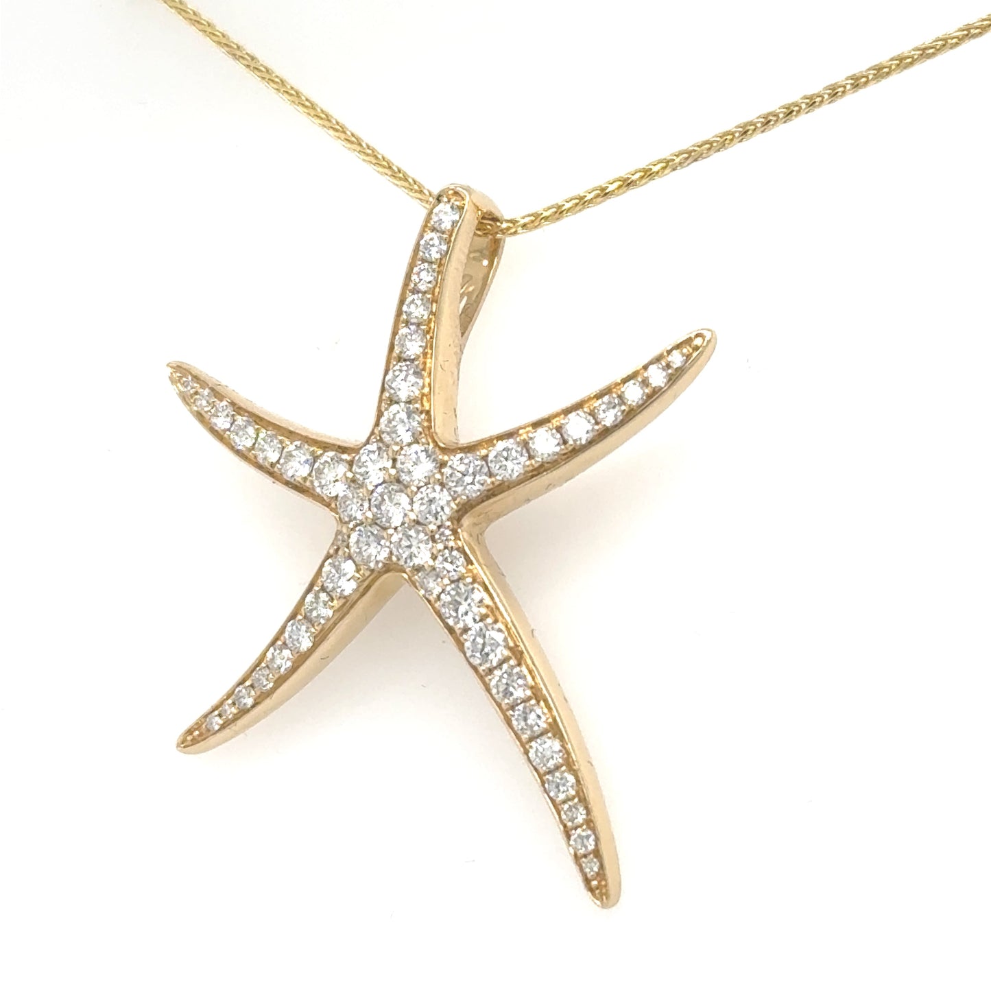 Yellow gold starfish pendant pavé‑set with round diamonds on a fine chain.