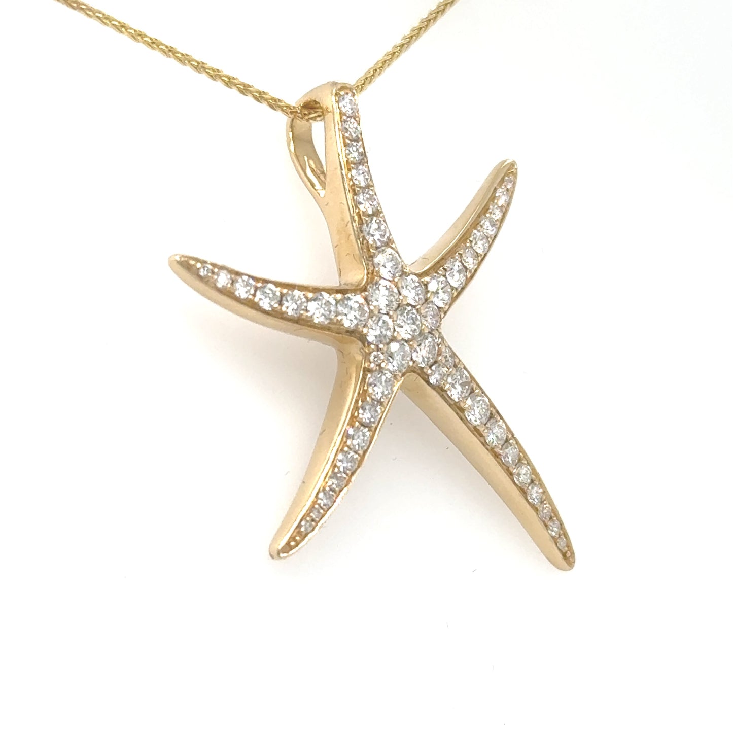 Yellow gold starfish pendant pave-set with round diamonds, shown on a chain.