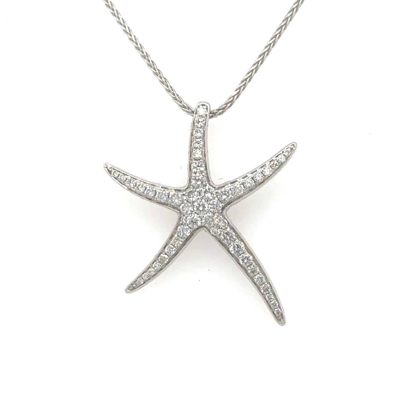 White gold starfish pendant paved with round diamonds, shown on a silver chain.