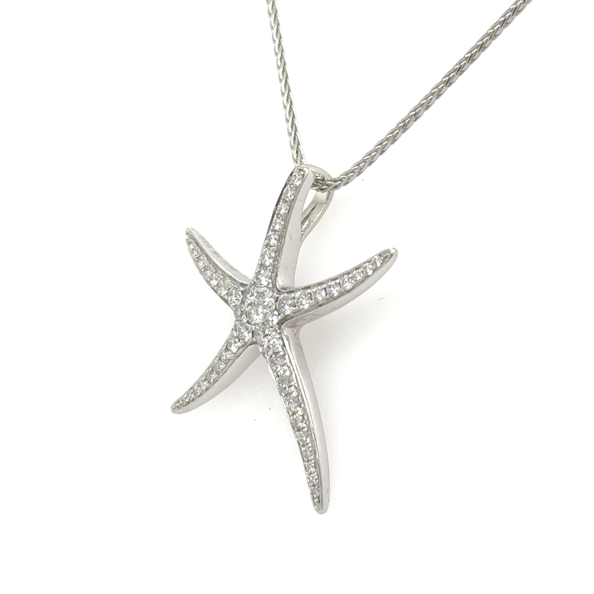 14K white gold starfish pendant paved with round diamonds, shown on chain.